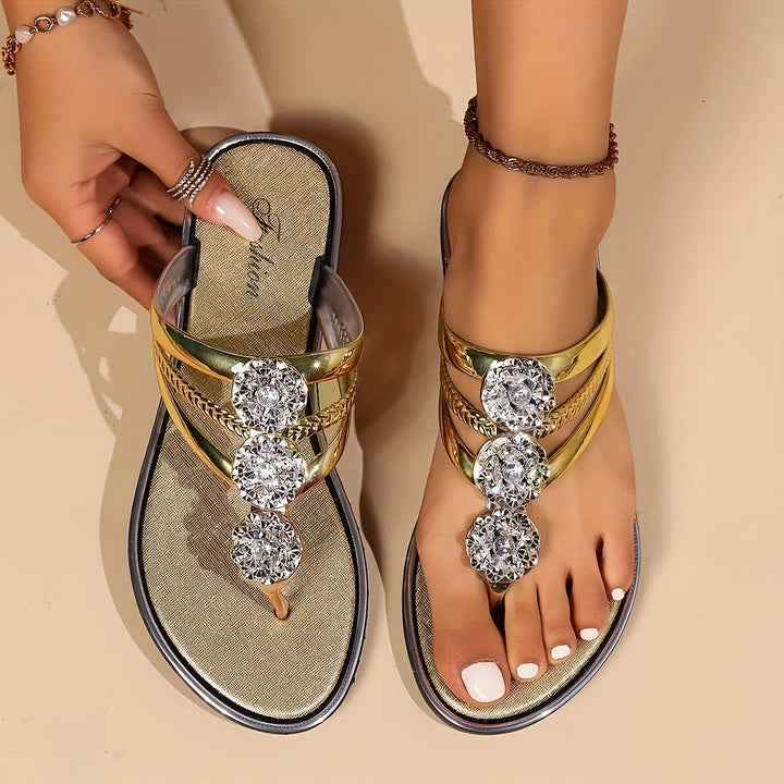 Gold metallic thong sandals with rhinestone t-strap and decorative crystal accents