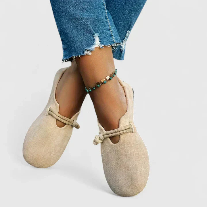Cream suede loafer flats with rope trim worn with ripped denim, flat lay