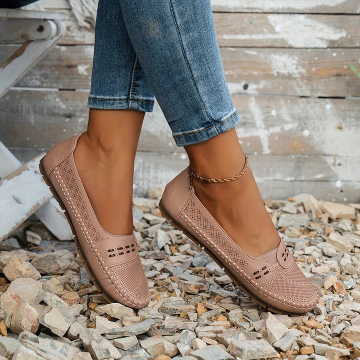 Beige perforated moc toe loafer flats with cushioned soles worn with rolled denim