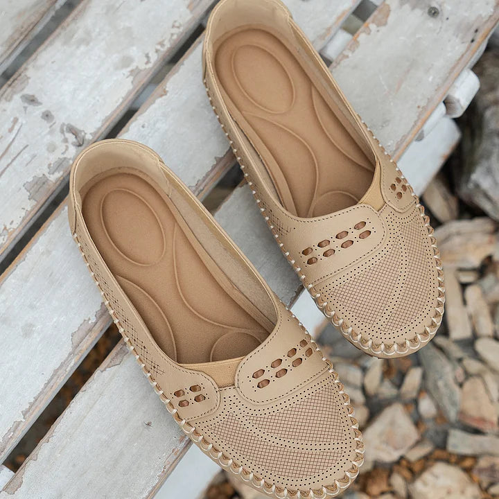Cushioned moc toe loafer flats in cream showing contoured insole and perforations
