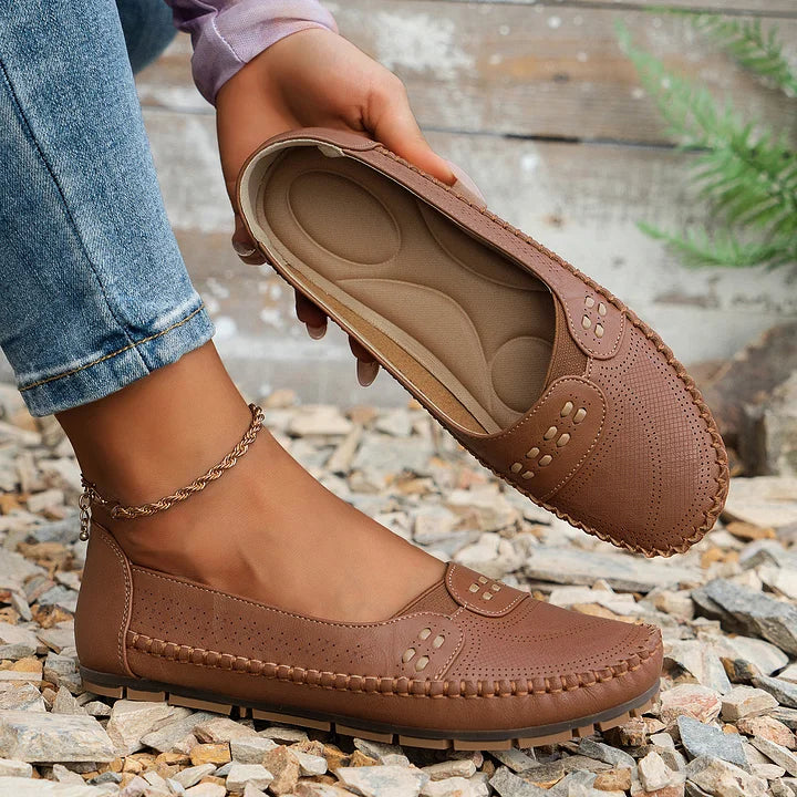 Cognac moc toe loafer flat held up showing cushioned footbed and perforated design