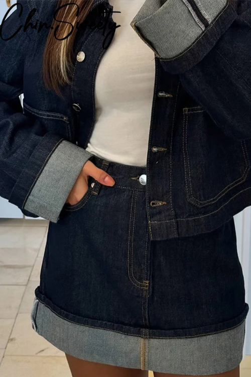 Close-up of women dark wash denim cropped jacket and mini skirt with cuffed hem detail.