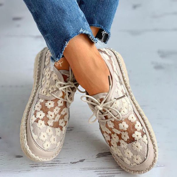 Women's beige floral embroidered lace-up sneakers with braided sole, angled view