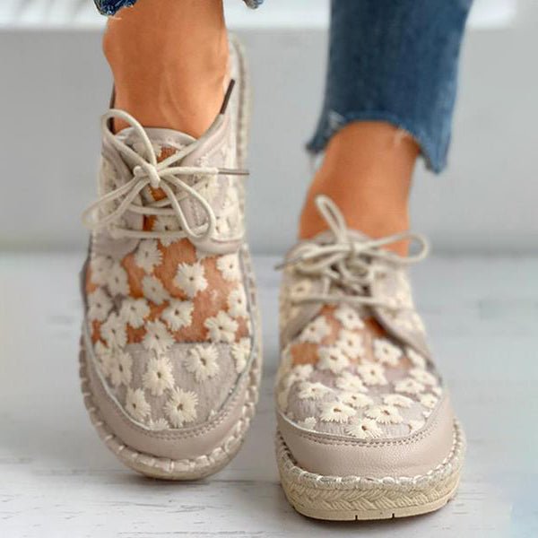 Women's beige floral embroidered lace-up sneakers with braided sole, close-up front