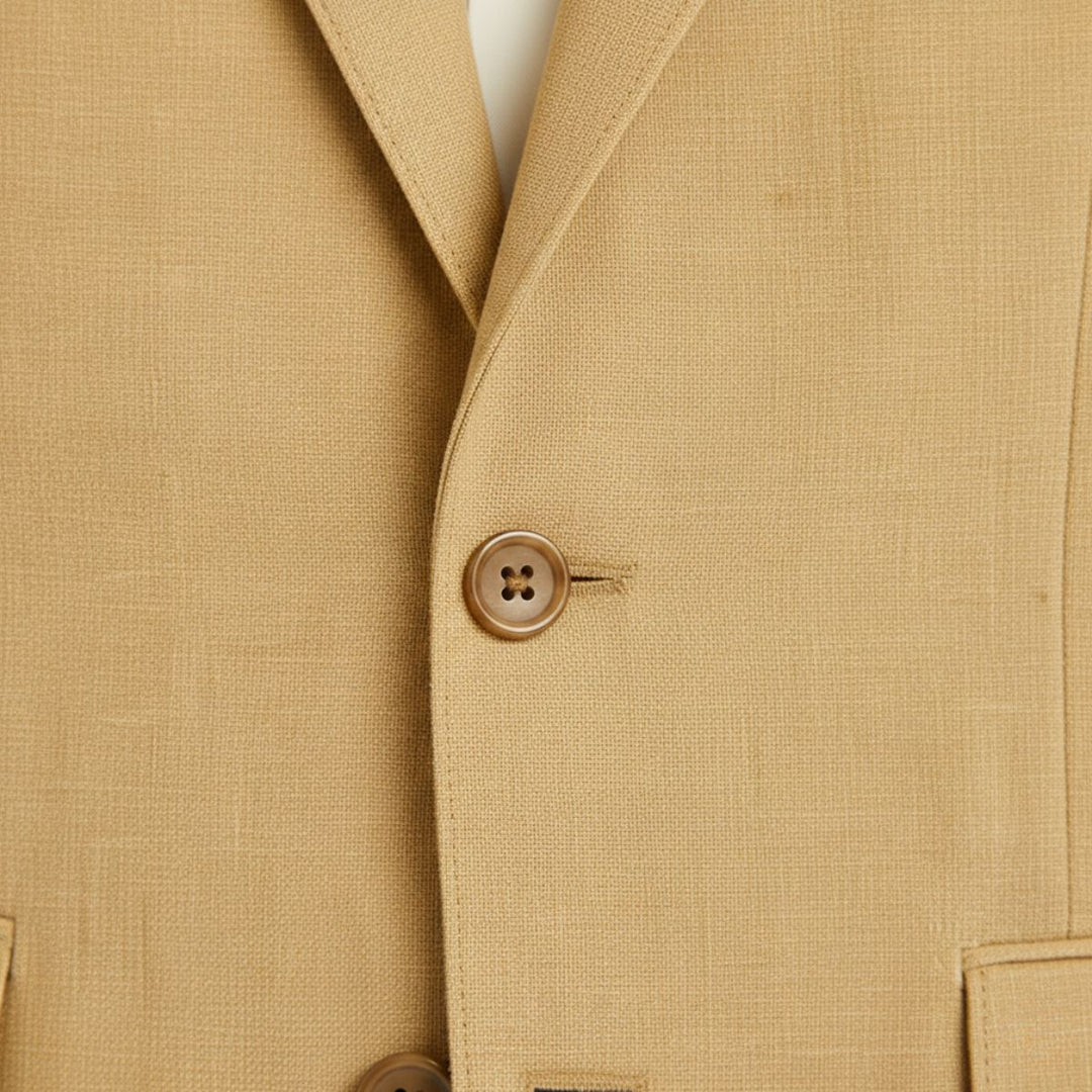 Tan linen blazer button detail showing four-hole tan button on textured fabric