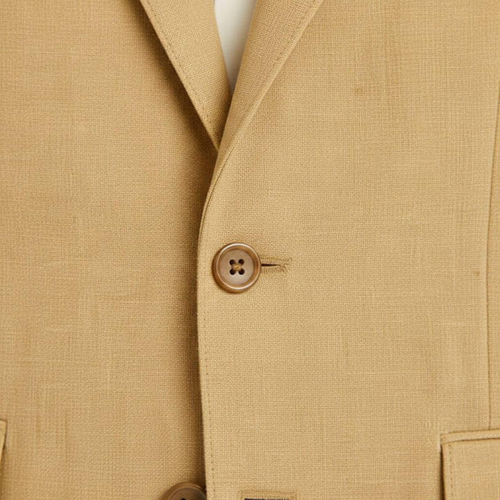 Tan linen blazer button detail showing four-hole tan button on textured fabric