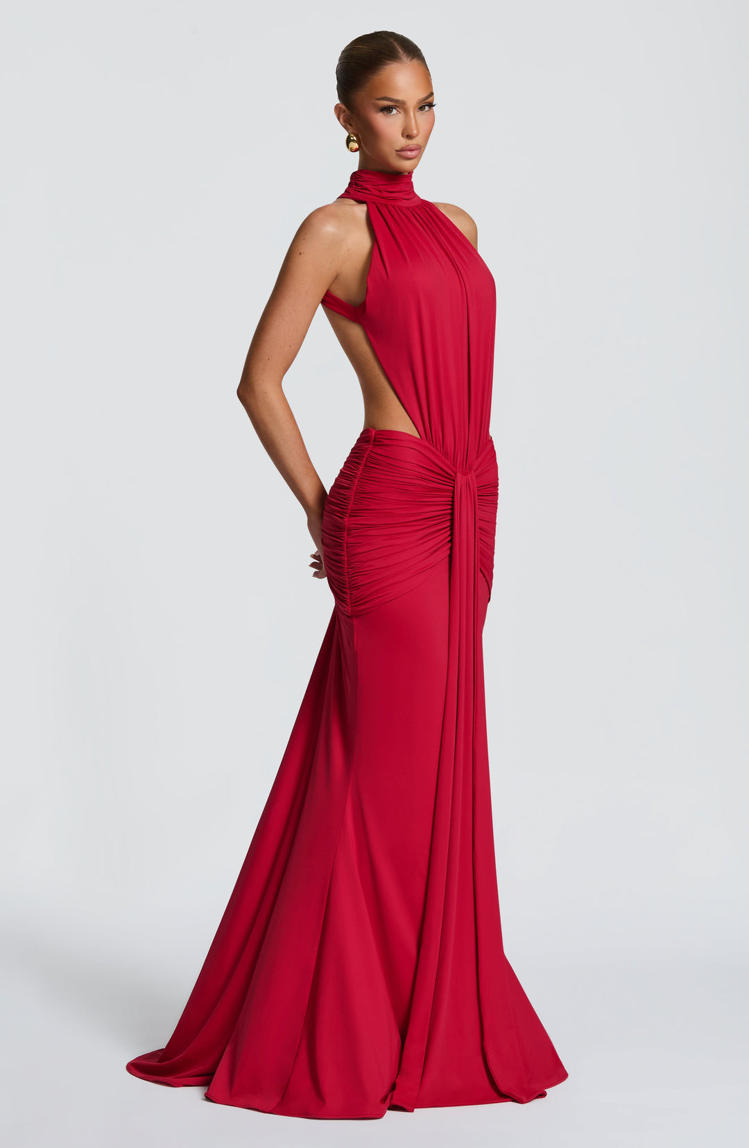 Women red halter maxi dress with side cut-outs and ruched detailing, side view of model