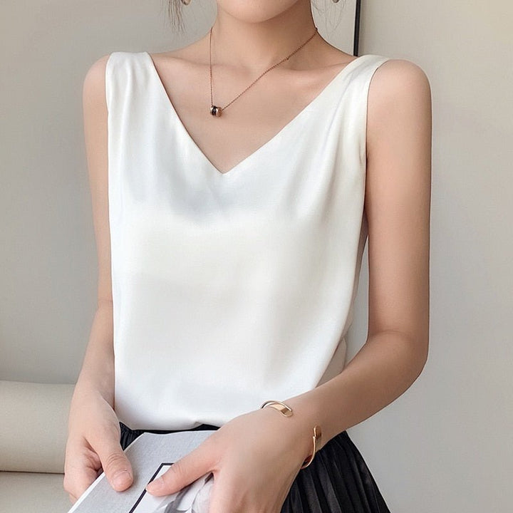 Women white sleeveless metallic knit V-neck top with gold bracelet