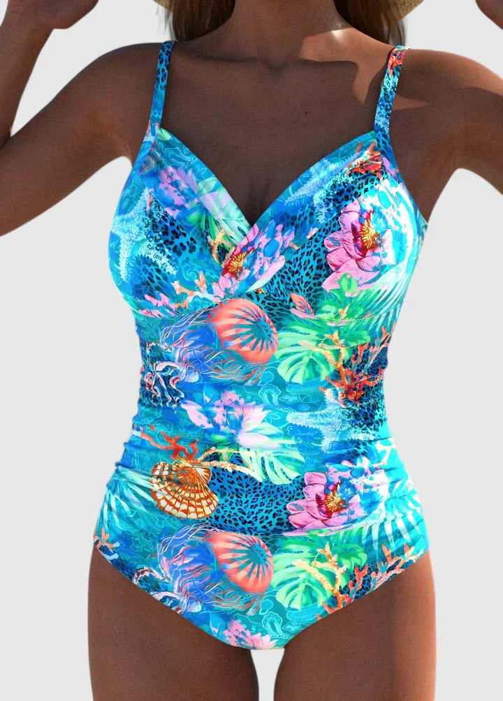 Women's tropical printed one-piece swimsuit with tie-back in bright blue with colorful coral and floral motifs, front view