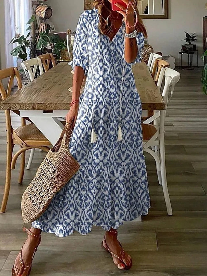 Women blue patterned maxi dress with V-neckline and short sleeves, front view indoors